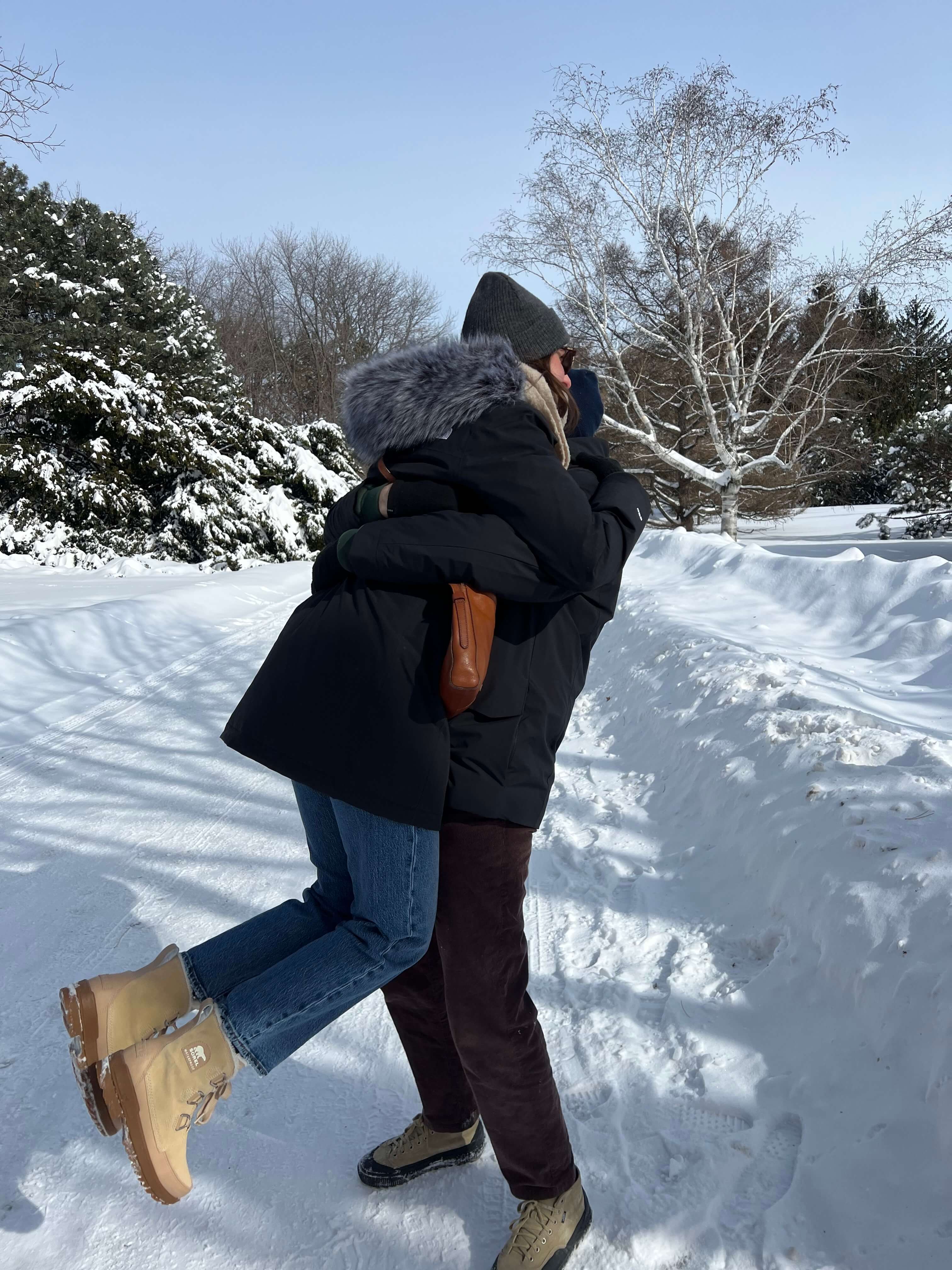 Mélanie marchant dans la neige en manteau noir